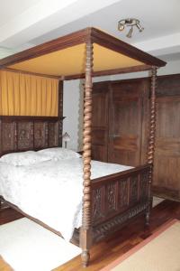橋連城的住宿－羅伊谷酒店，配有木制家具的客房内的天蓬床