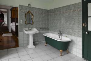 a bathroom with a green tub and a sink at Le Val du Roy in Joinville