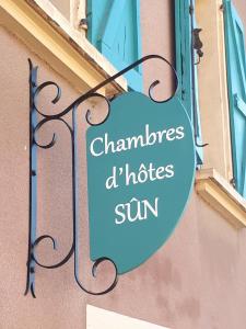 a sign hanging on the side of a building at Sûn Chambres d'hôtes in Rabastens