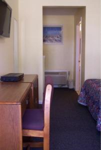 Habitación con escritorio y dormitorio con cama. en Weathervane Motel Lanesboro, en Lanesborough
