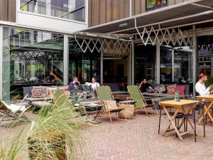 a group of people sitting at tables outside of a building at Q-Factory Hotel in Amsterdam