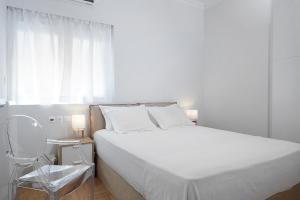 アテネにあるLux Central Apt at Kolonaki Areaの白いベッドルーム(ベッド1台、椅子付)