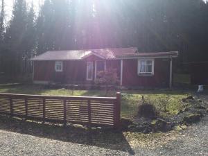een klein rood huis met een hek ervoor bij Stuga i Ullared in Ullared