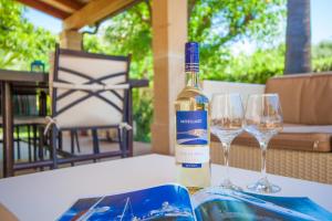 una bottiglia di vino seduta su un tavolo con due bicchieri di Can Boi Den Cifre a Pollença