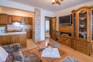 een woonkamer met een bank en een tv bij Apartman Slavko in Krk