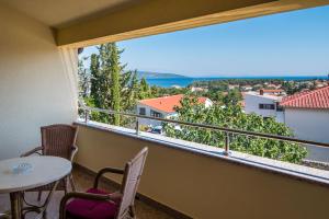 een balkon met een tafel en stoelen en een groot raam bij Apartman Slavko in Krk