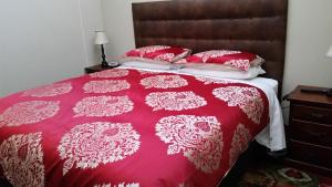 a bed with a red and white comforter and pillows at Eagle Foundry Bed & Breakfast in Gawler