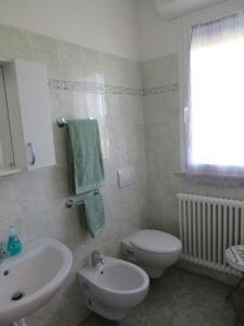 bagno con servizi igienici bianchi e lavandino di Appartamento l'Ulivo a Gradara