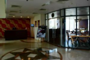 a living room with a television and a table at Kingsgate Hotel Doha by Millennium Hotels in Doha