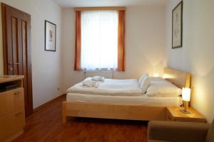a bedroom with a large bed with a window at Penzion na Ostrově in Český Krumlov