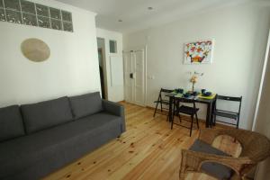 uma sala de estar com um sofá e uma mesa em My Mouraria Suites em Lisboa