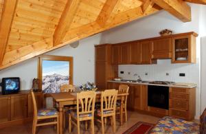 a kitchen with a table and chairs and a mountain at Residence Hotel Anna in Passo del Tonale
