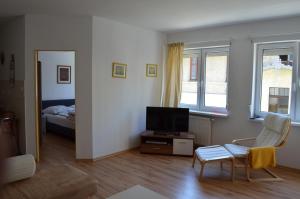a living room with a television and a bed at Apartament Irek 1000L PP in Międzyzdroje
