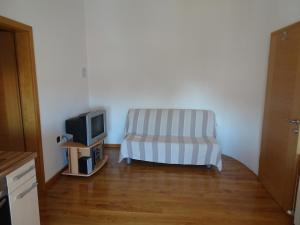 a living room with a chair and a tv at Apartments Premantura in Premantura