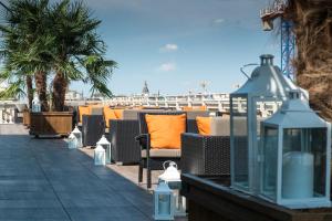 - une rangée de chaises avec des oreillers orange sur une plage dans l'établissement Turin Palace Hotel, à Turin