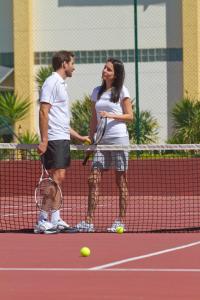 a man and a woman playing tennis on a tennis court at Eurotel Altura in Altura