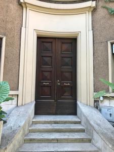 ローマにあるThe Queenの階段のある建物の木製ドア
