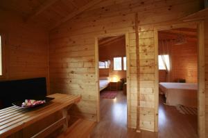 Cabaña de madera con una habitación con 2 camas y una mesa en La Cabaña Rural, en Paúl