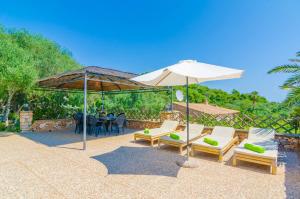 een patio met stoelen, een parasol en een tafel bij Cas Conco in S'Horta