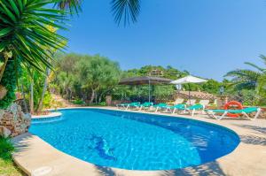 a pool with chairs and umbrellas at a resort at Cas Conco in S'Horta