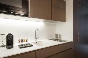 a kitchen with a sink and a microwave at Relais Louvigny in Luxembourg