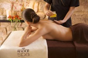 a woman getting a massage at a spa at Vertigo Hotel, By Marriott, a Member of Design Hotels in Dijon