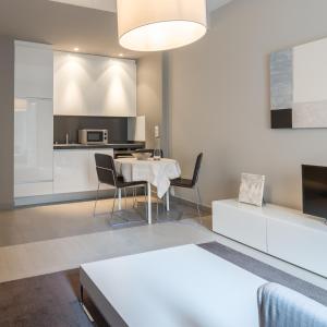cocina y sala de estar con mesa y sillas en Four Stars Aparthotel, en Luxemburgo