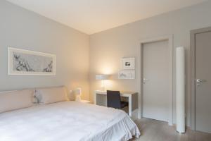 ein weißes Schlafzimmer mit einem Bett und einem Schreibtisch in der Unterkunft Four Stars Aparthotel in Luxemburg (Stadt)