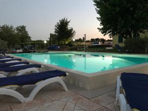 a large swimming pool with lounge chairs in front of it at Albergo Quattro Pini in Pozzolengo