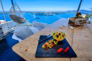 a table with strawberries and a bowl of fruit on it at Modernity Suites in Fira