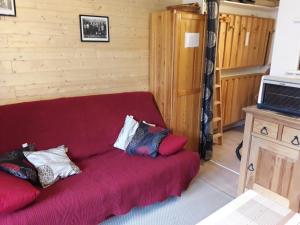 a living room with a red couch with pillows on it at appart st gervais le Topaze in Saint-Gervais-les-Bains