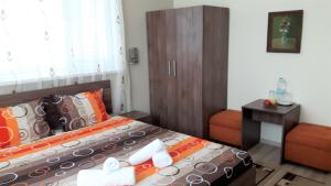 niewielka sypialnia z łóżkiem i krzesłem w obiekcie Guest House Radoychevi w mieście Welingrad