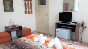 a room with a living room with a tv and a table at Guest House Radoychevi in Velingrad