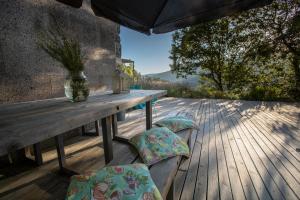 un tavolo e sedie in legno su una terrazza di legno di Casa de Campo De Torneiros a Unhais da Serra