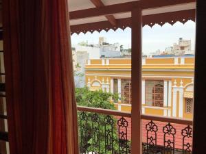 a window with a view of a building at Maison Petite Singapore in Puducherry