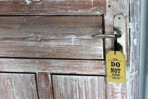 a do not disturb sign hanging on a wooden door at Bingin Inn in Uluwatu +81 photos