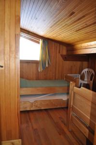 Etagenbett in einer Holzhütte mit Fenster in der Unterkunft Petit HAUTLIEU in Les Saisies
