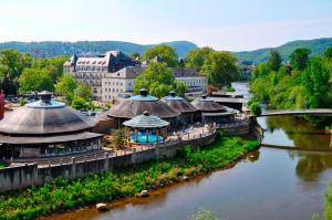 einen Blick über einen Fluss mit Gebäuden und einer Brücke in der Unterkunft Parkhotel Kurhaus in Bad Kreuznach