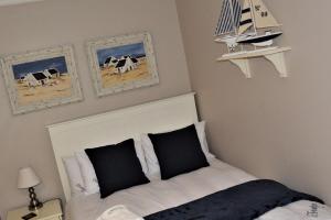 sypialnia z łóżkiem z czarno-białymi poduszkami w obiekcie Frinton on Sea 7 w mieście Ballito