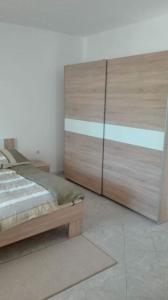 um quarto com uma grande cama de madeira e uma grande cómoda em Apartman Desi em Funtana