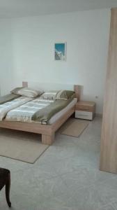 a bedroom with a bed and a white wall at Apartman Desi in Funtana