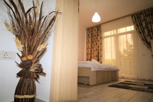 a bedroom with a bed and a vase with flowers at Aby sunrise in Orşova