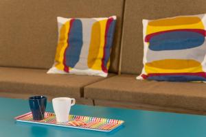 a tray with a cup on a table next to a couch at Hostel Antique in Pula