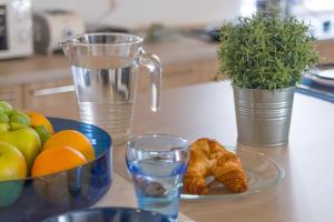 a table with a plate of fruit and a glass of water at Hostel Antique in Pula