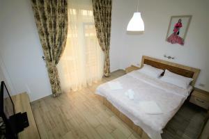 a bedroom with a white bed and a window at Aby sunrise in Orşova