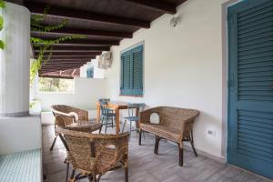 a patio with chairs and a table and a door at Titina Village Porto in Vulcano