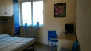 1 dormitorio con cama, escritorio y ventana en Corte Valesana, en Lazise