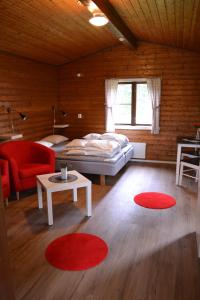 a room with a bed and a table and red chairs at Doro Camp Lapland in Dorotea