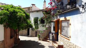 an alley with a building with flowers and a balcony at Ca La Pepa in Begur