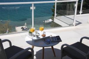 een tafel met een dienblad met eten en twee glazen sinaasappelsap bij Beachfront Apartments - Villa Vita in Stara Novalja